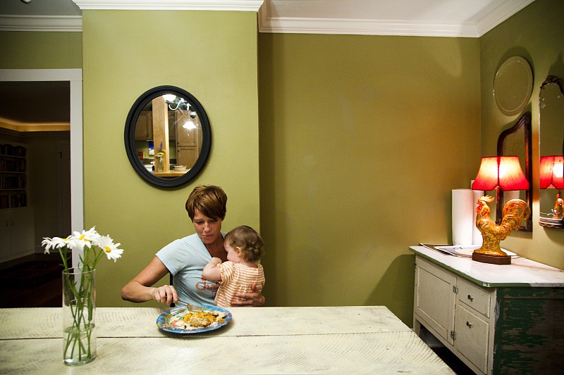 母亲和女儿(6-12个月)在家吃饭图片下载