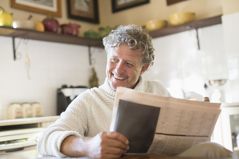 一个老人在厨房看报纸图片素材