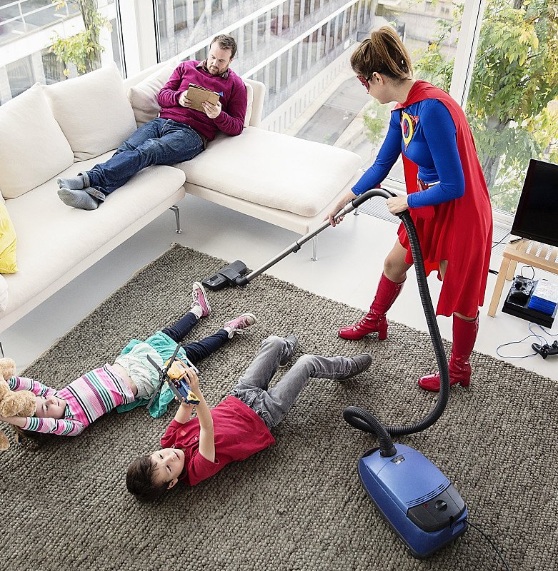 超级英雄在客厅和家人一起吸尘图片素材
