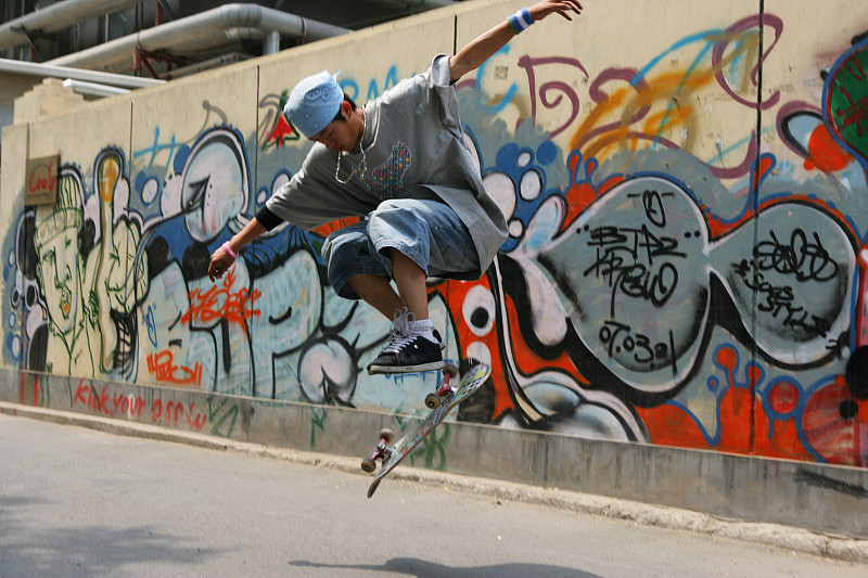 男青年在798艺术区玩滑板图片下载