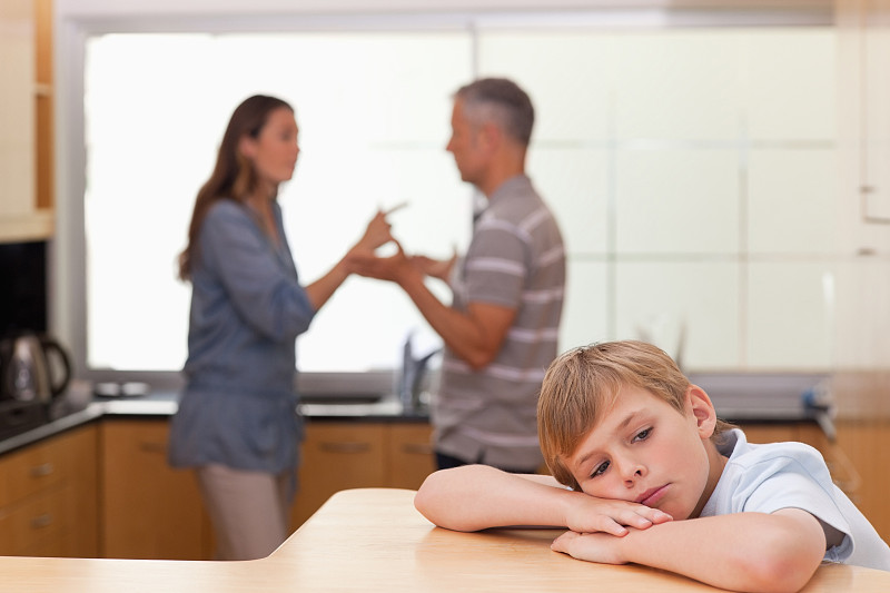悲伤的小男孩听到他的父母在厨房争吵图片素材