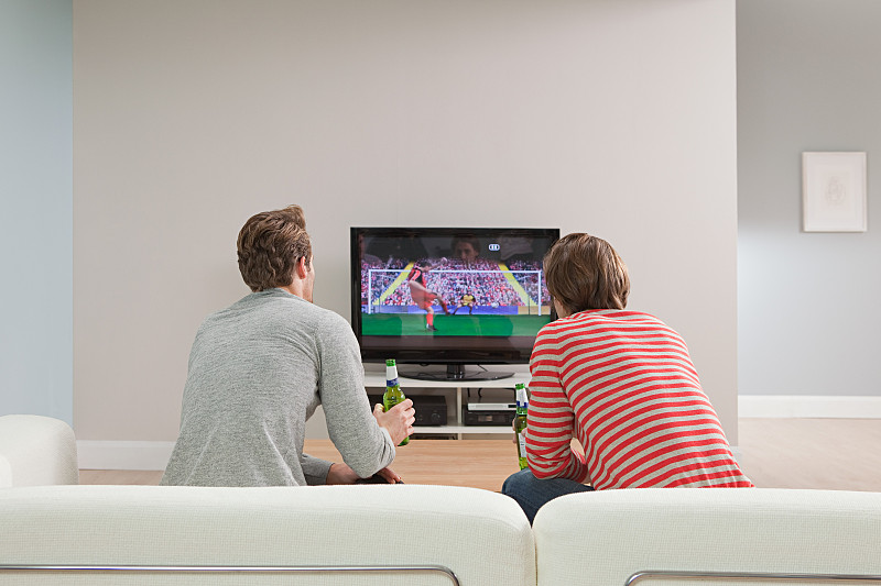 两个年轻人在电视上看足球比赛图片下载
