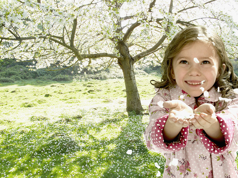 女孩从树上摘下花瓣图片素材