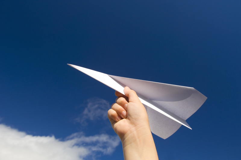 7、一只手拿着纸飞机看天空图片素材