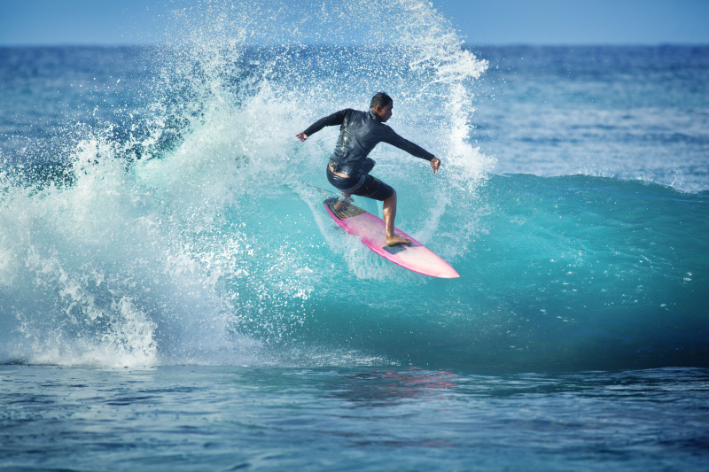 一名年轻人在夏威夷考艾岛的海滩上冲浪图片下载