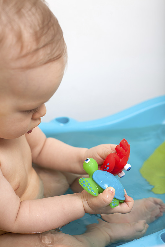 小男孩在蓝色的浴缸玩具洗澡的时间图片下载
