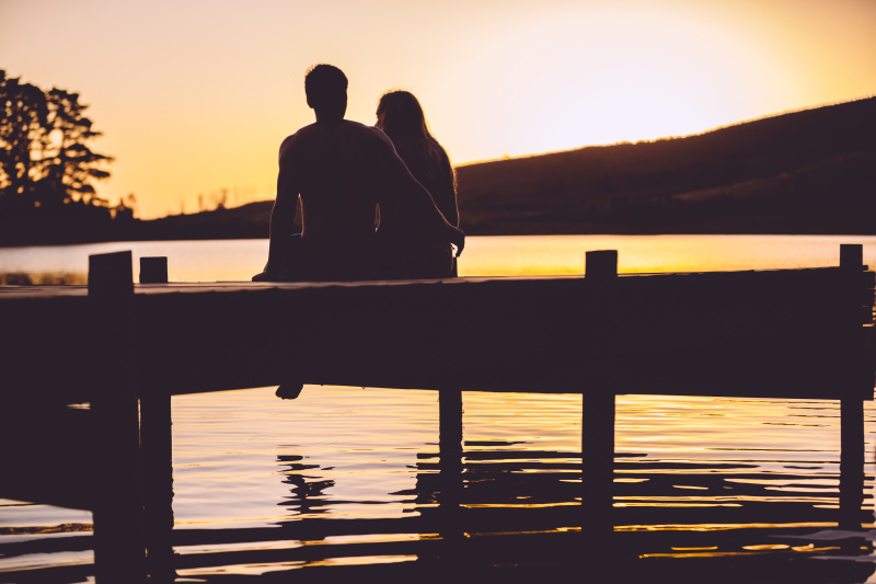 日落时分，一对情侣站在码头上图片下载