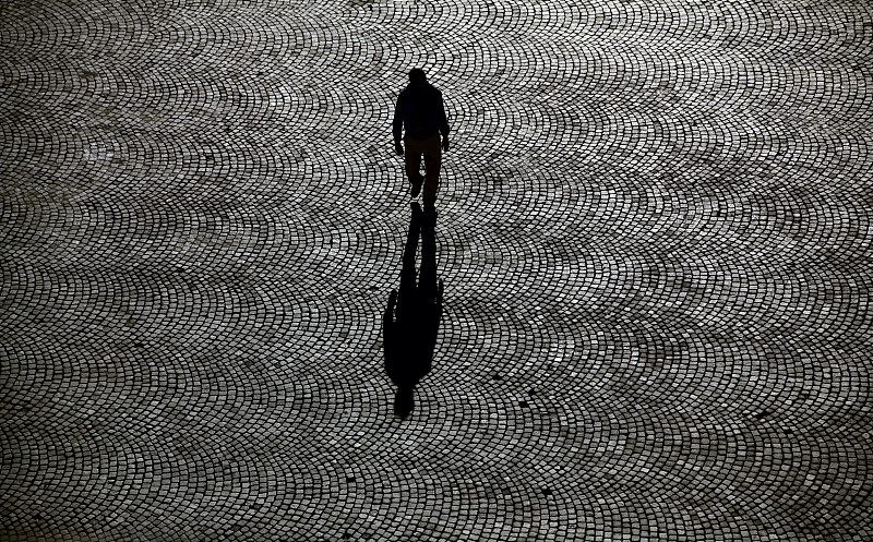 一个人独自走在铺满鹅卵石的街道上图片下载