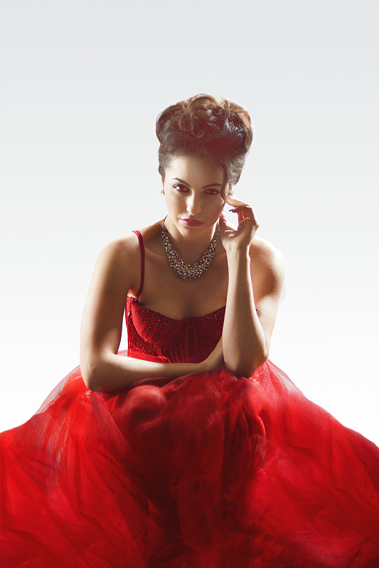 一个穿着优雅的红色连衣裙的女人的肖像图片下载