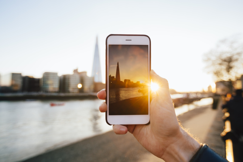 男子用智能手机拍摄伦敦天际线图片素材