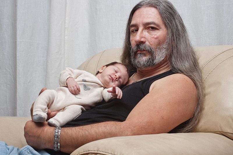 父亲抱着熟睡的新生儿图片下载