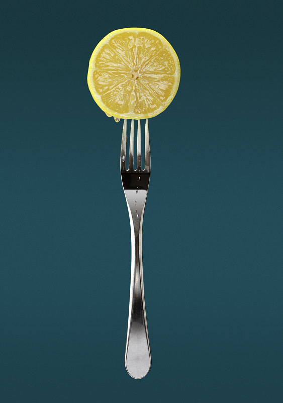 用叉子叉上新鲜的柠檬片图片下载