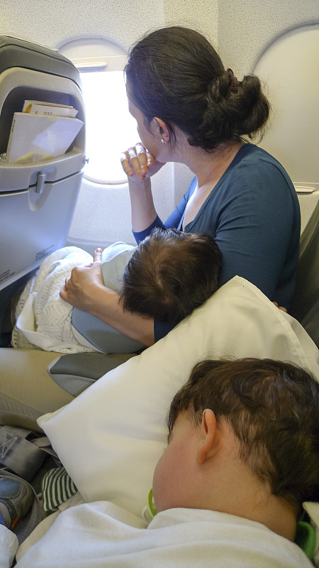 带着两个孩子坐飞机旅行的母亲图片下载
