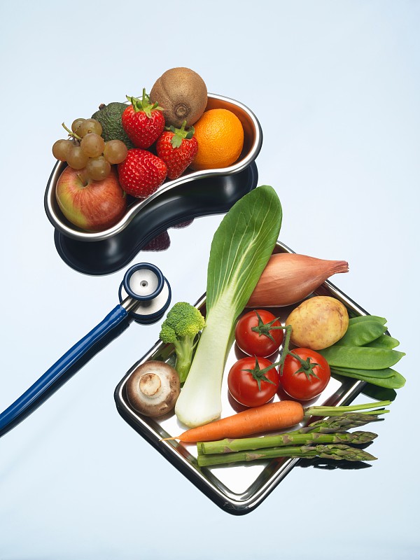 Stethoscope between trays of fresh fruits and vegetables图片素材