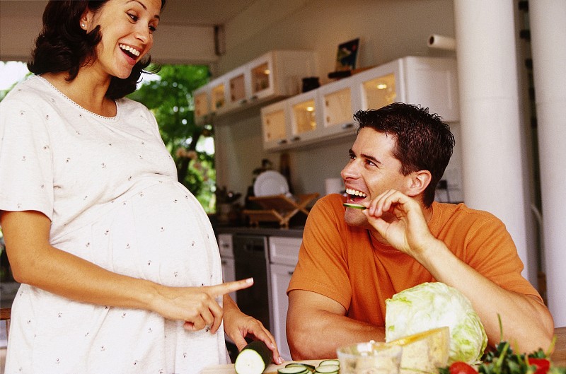 一个孕妇在餐桌上和她的丈夫说话图片下载