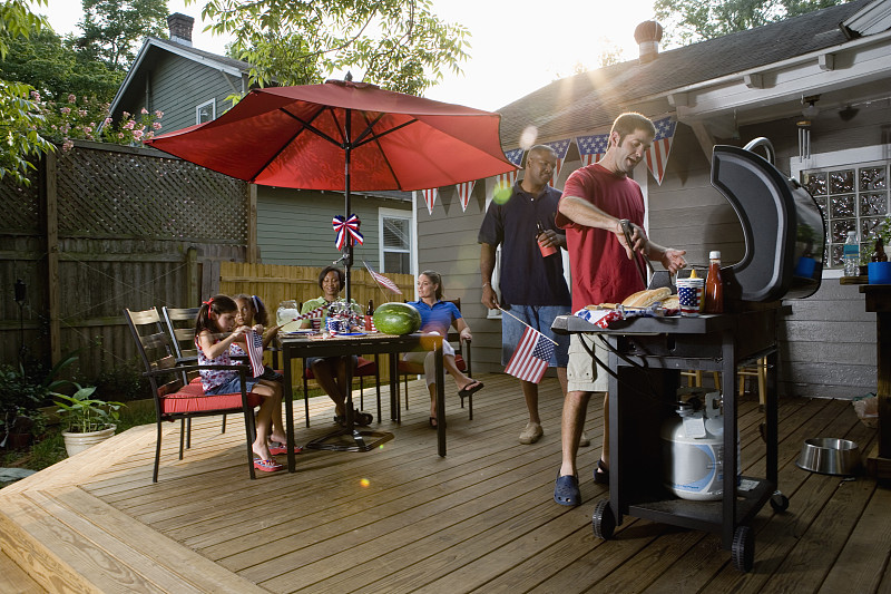 两个家庭在后院院子里庆祝独立日图片素材