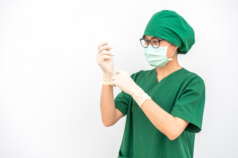 一幅亚洲护士举起双手的肖像，戴着橡胶手套在医院手术室。为手术工作做好准备。图片素材