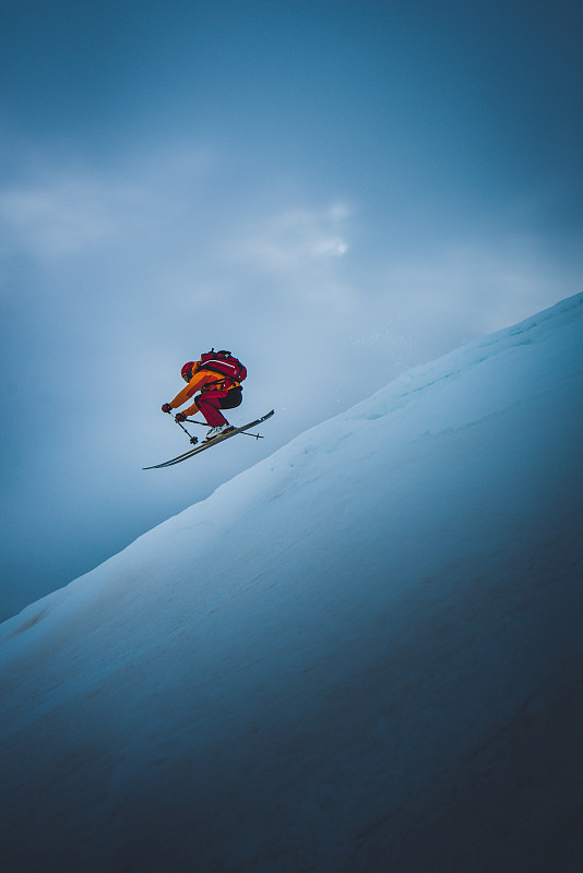 滑雪者从滑雪跳台上跳下，身后是天空图片素材