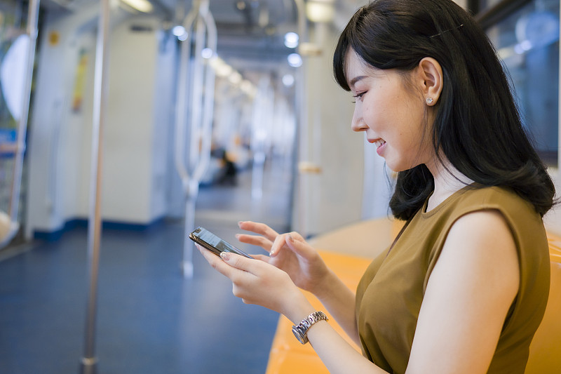 年轻女子在地铁里看手机图片下载