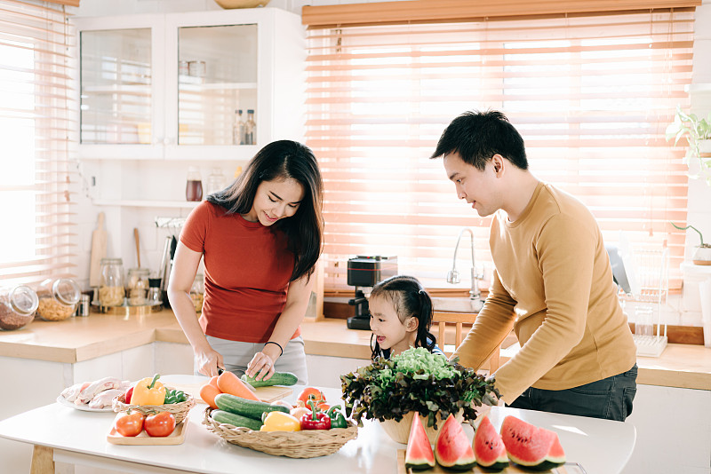 亚洲家庭为了健康在厨房里一起做饭图片素材