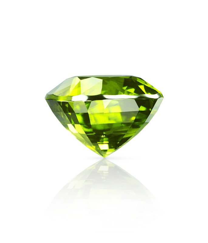 闪光的淡绿色橄榄石宝石躺在一个白色的表面上有一个下降的阴影和反射的特写侧视图图片下载