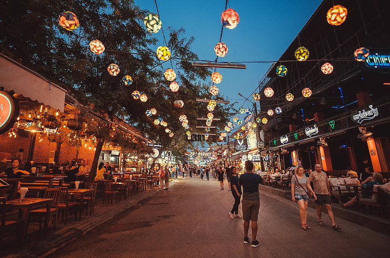 人们在亚洲城市的主要街道上享受快乐和晚餐，有酒吧，咖啡馆和餐馆图片素材