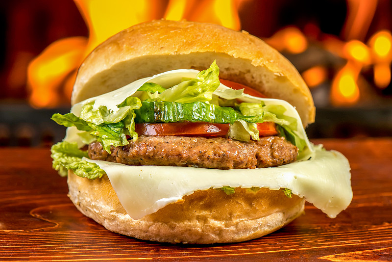 汉堡在餐厅厨房的正面视图与火从炉子的背景图片下载