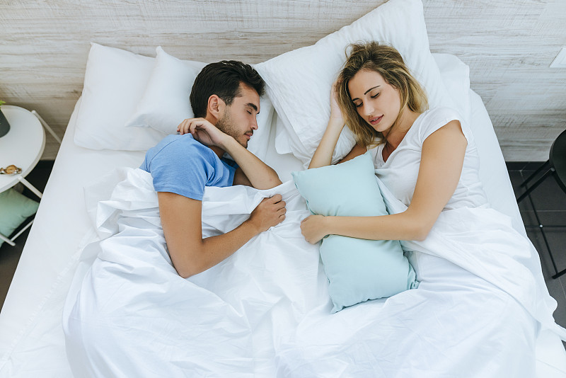 高角度的夫妇睡在床上在家里的卧室图片下载