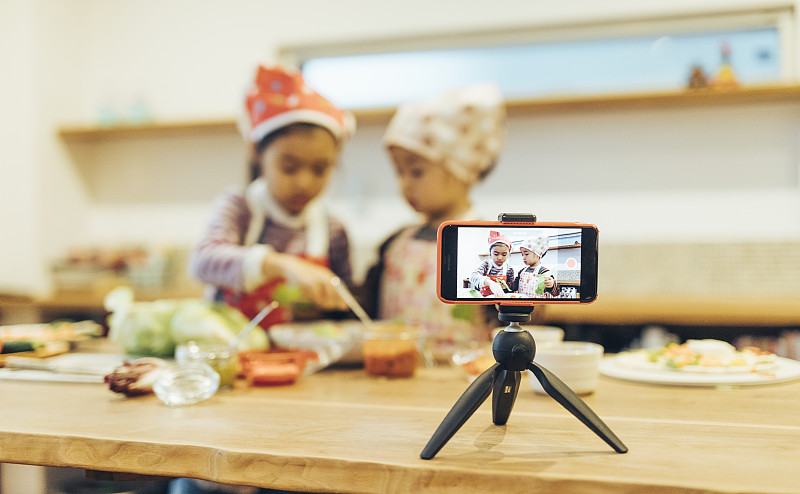 创意儿童用智能手机制作烹饪节目图片素材