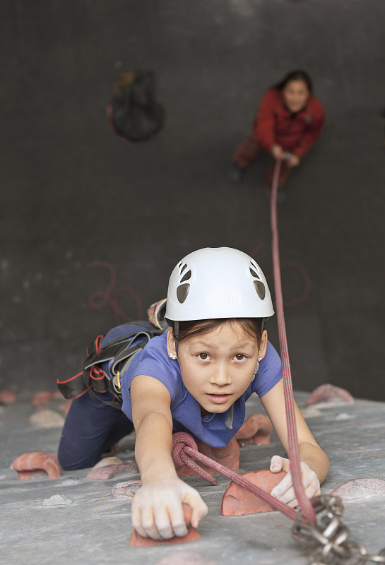在英国，一个小女孩在爬室内攀岩墙图片下载