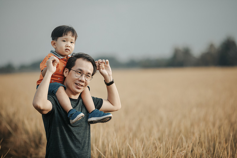 周末早上，一个亚裔华人家庭在稻田里打发闲暇时间，父亲抱着他的孩子，男婴肩上享受图片下载