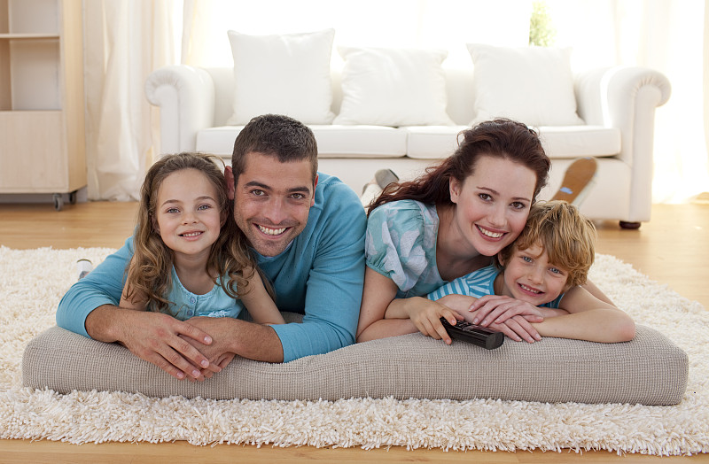 微笑的家人在客厅的地板上图片素材