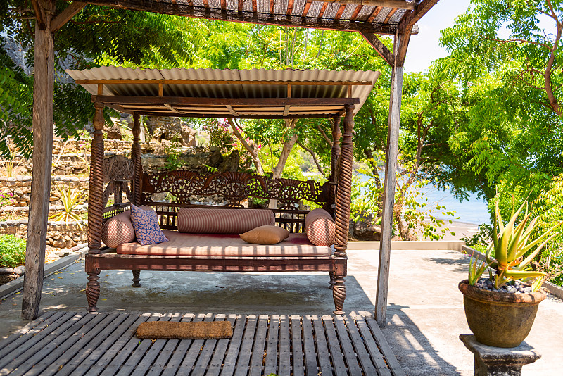 漂亮的木制复古长椅。亚洲风格室内。酒店度假村。印尼巴厘岛图片素材