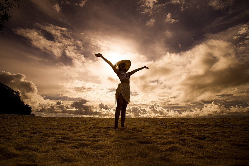 一名亚洲女子在晴朗的日子穿着比基尼和海帽在沙滩上图片下载