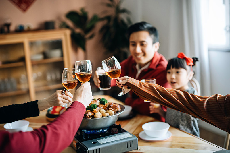 三代快乐的亚洲家庭庆祝中国新年，一边品尝美味的传统中国菜，一边品尝团圆饭图片素材