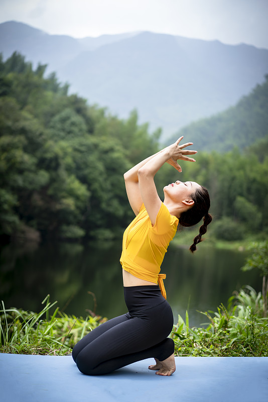 一个女人在湖边做瑜伽图片下载