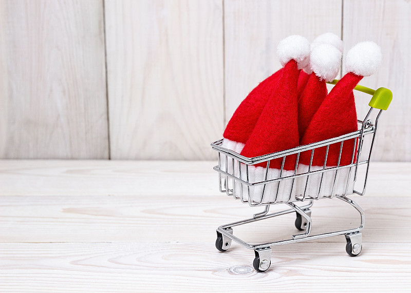 带圣诞老人小帽子的购物篮。圣诞节的模式。图片下载