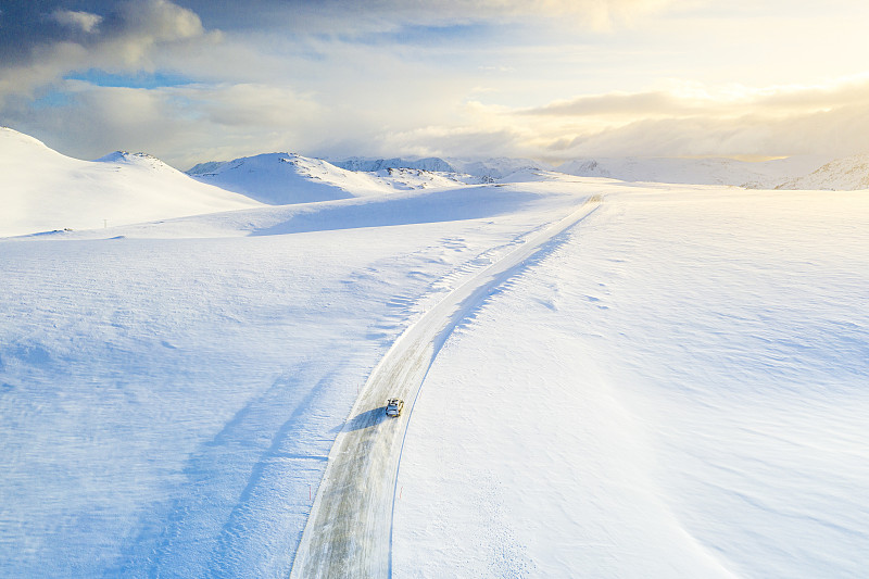 一辆汽车行驶在通往挪威芬兰马克北卡普的雪地上图片素材