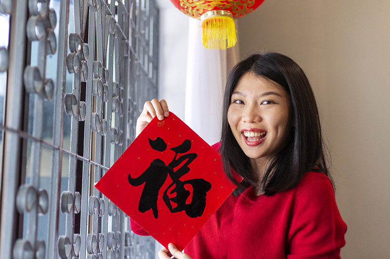 美丽的女孩拿着对联庆祝中国新年图片下载