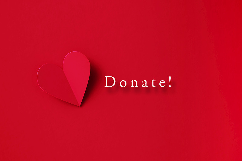 捐赠概念-捐赠信息旁边的折叠红心形状红色背景图片下载