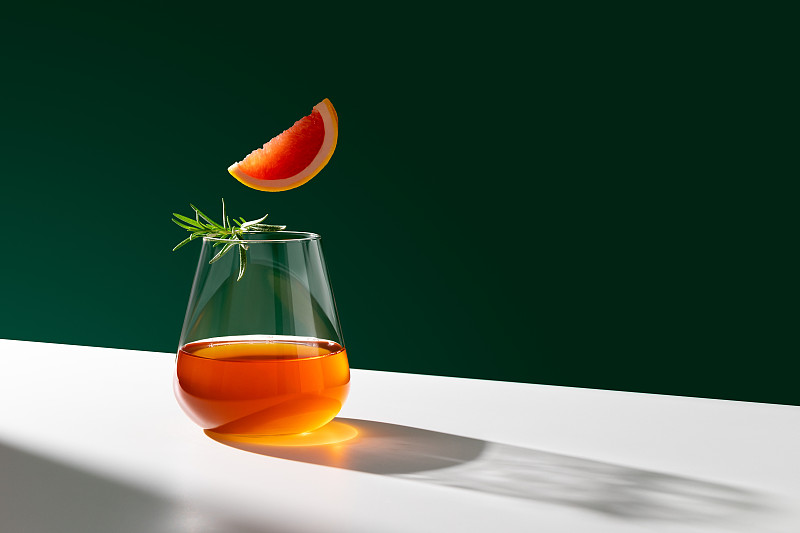 一杯新鲜的尼格罗尼鸡尾酒，配上橙片，点缀上迷迭香。副本的空间。图片下载