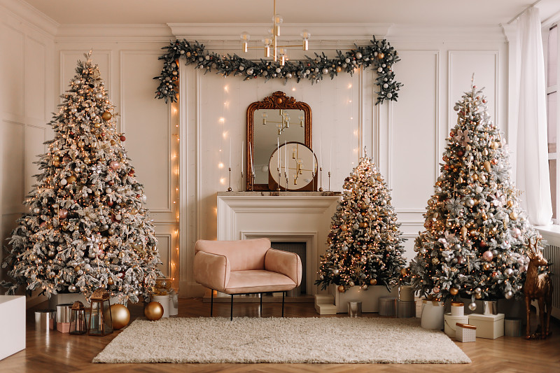 圣诞节的概念。在冬天的新年前夜，公寓宽敞明亮的客厅里有一个豪华的现代风格的壁炉，装饰着圣诞球和圣诞树花环。文本的地方图片下载