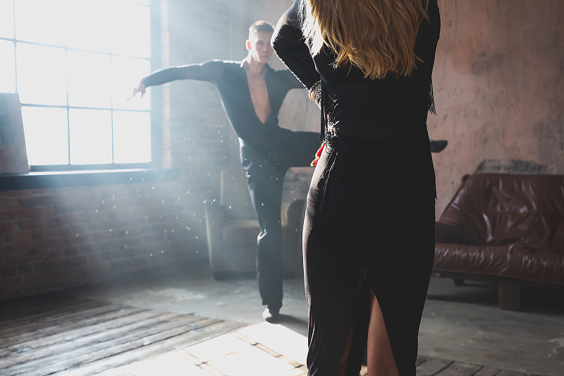 两个专业交际舞演员的一对腿在阁楼工作室跳舞。美丽的艺术表演伴随着浓浓的烟雾。运动生活的概念。激情与情感之舞。图片下载