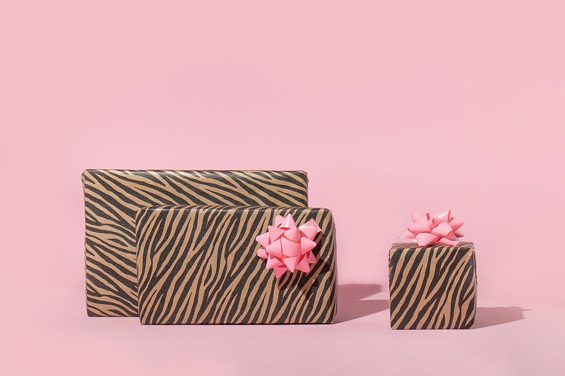 圣诞创意布局上的礼物在柔和的粉色背景。八九十年代的审美时尚假日概念。迷你新年派对的想法。图片下载