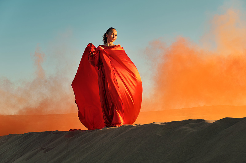 穿着红裙子的女人在沙漠里跳舞图片下载