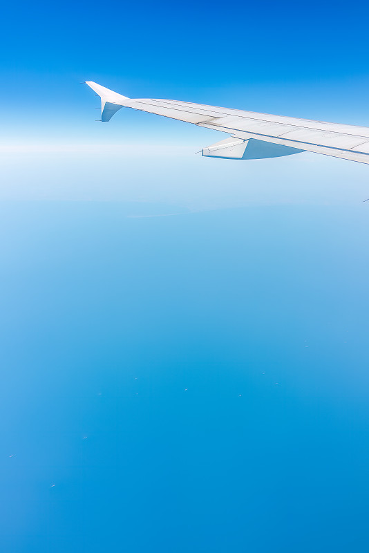 从飞机窗口看到美丽多云的天空和飞机的机翼图片下载