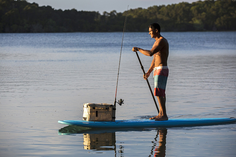 年轻人与他的渔具站在一个桨登郊游图片下载