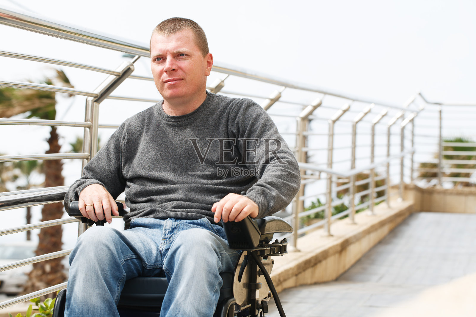 一名中年男子坐着轮椅下斜坡照片摄影图片