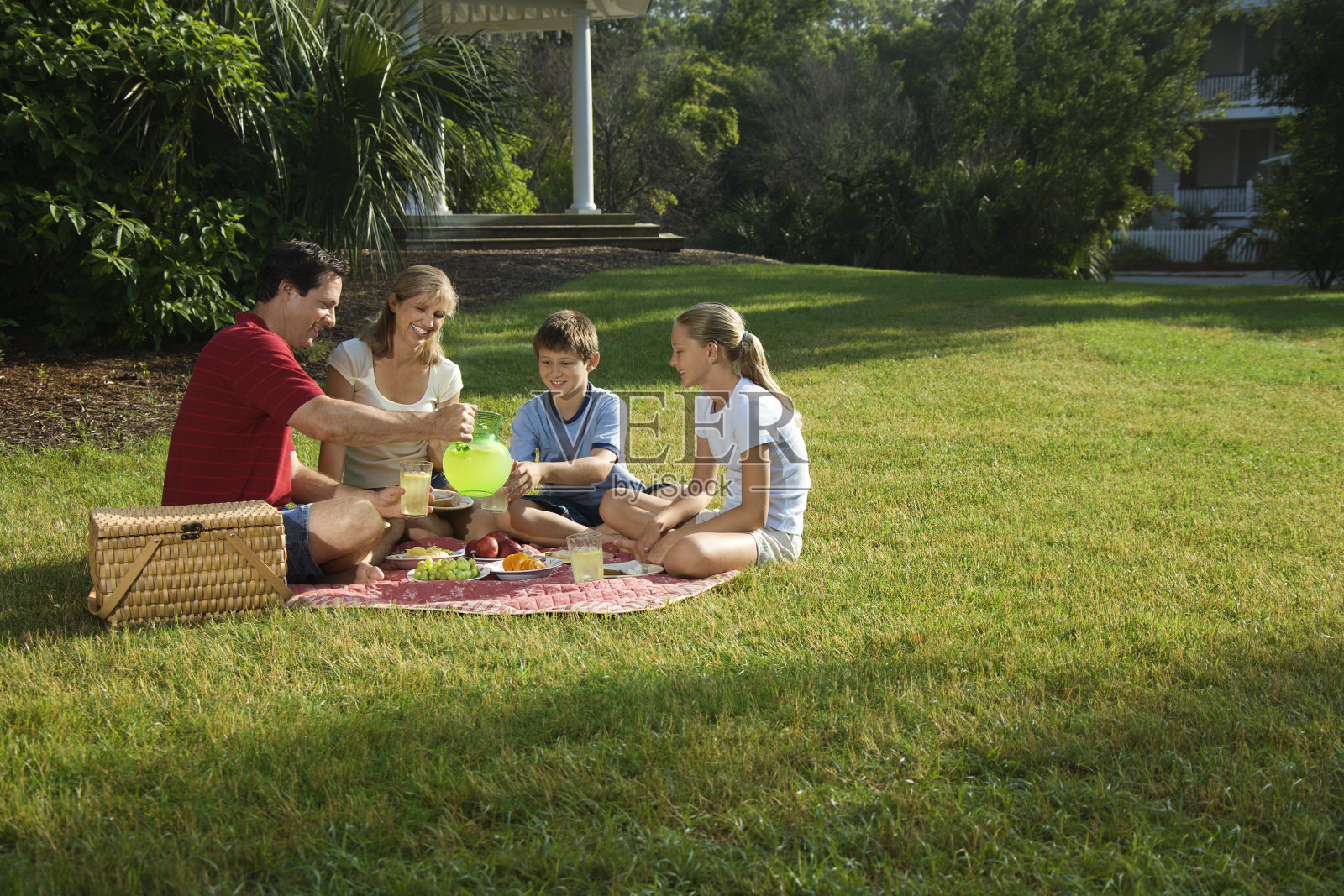 一家人在公园野餐。照片摄影图片
