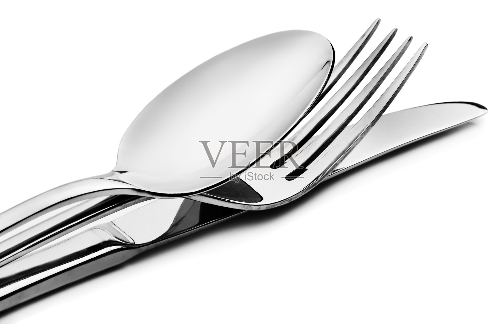 勺子，叉子和刀堆放在白色的背景上照片摄影图片
